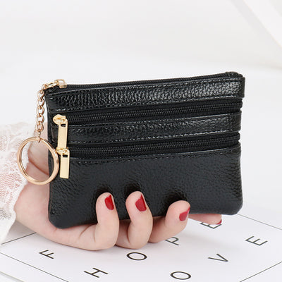 Women's Coin Purse Short and I in black leather with multiple zippered compartments and a keyring attached.