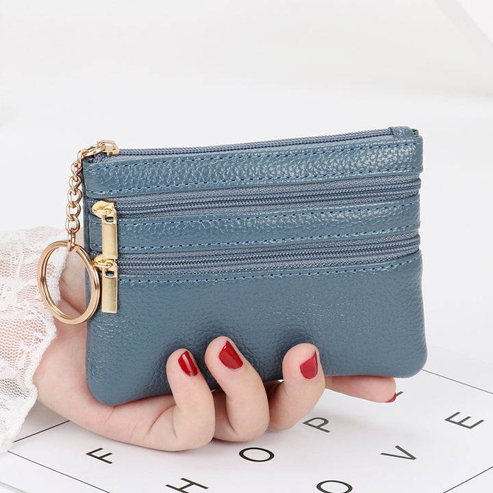Women's Coin Purse Short and I in black leather with multiple zippered compartments and a keyring attached.