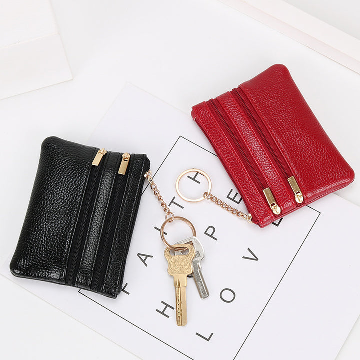 Women's Coin Purse Short and I in black leather with multiple zippered compartments and a keyring attached.