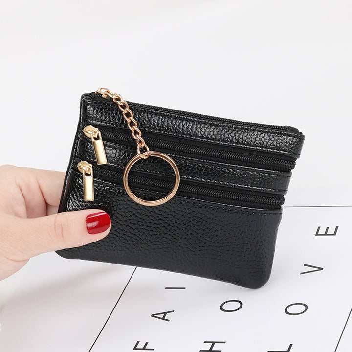 Women's Coin Purse Short and I in black leather with multiple zippered compartments and a keyring attached.